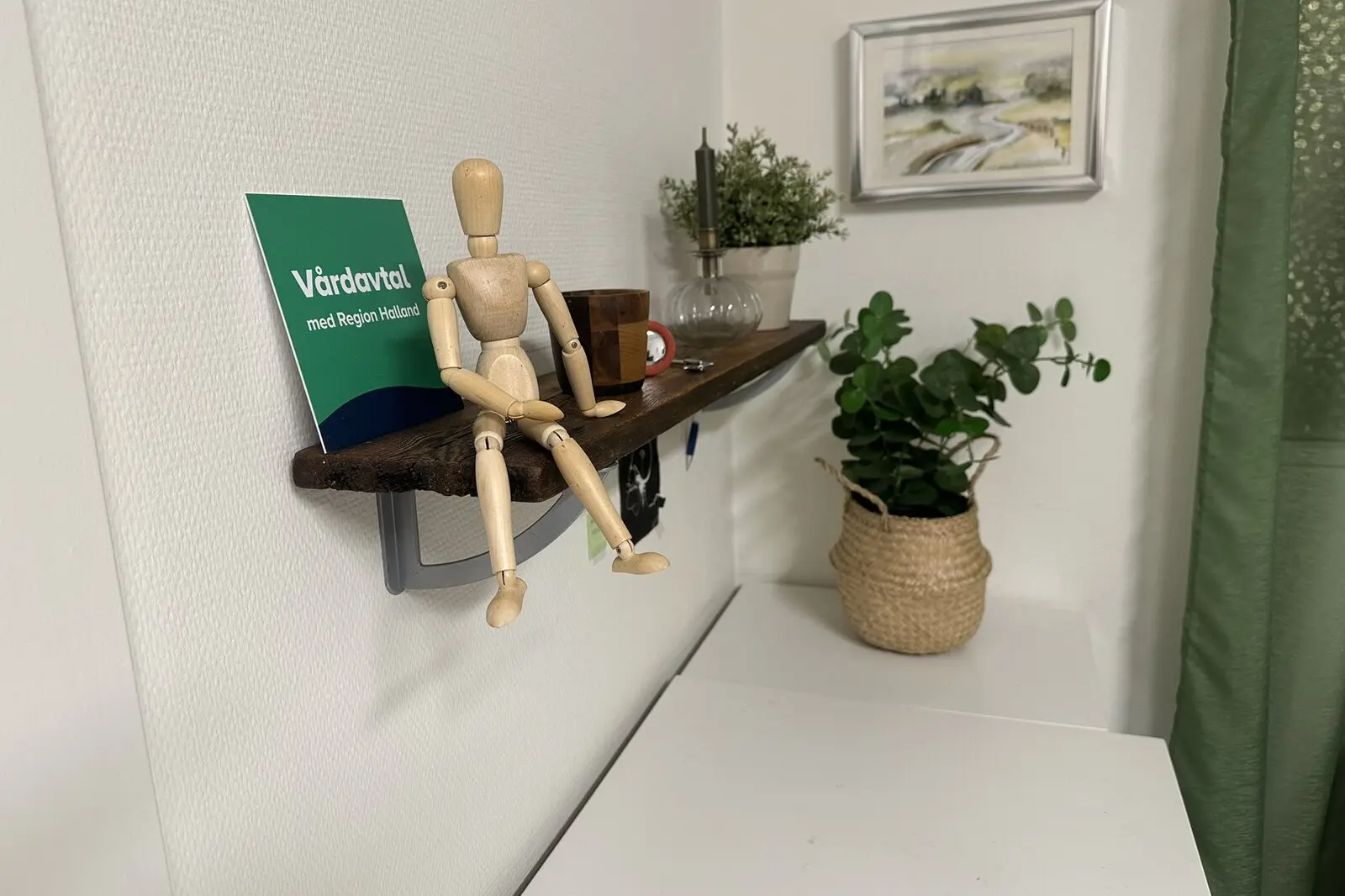 Träfigur på en hylla bredvid skylten Vårdavtal med Region Halland